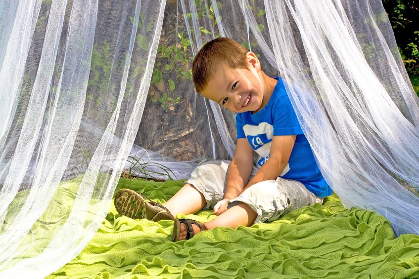 Niño pequeño dentro de una mosquitera